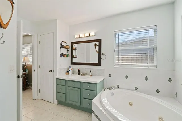 a bathroom with a tub sink and mirror