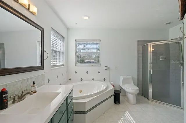 a bathroom with a granite countertop sink a toilet and shower