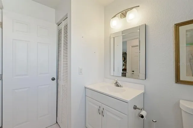 a bathroom with a sink a toilet and a mirror