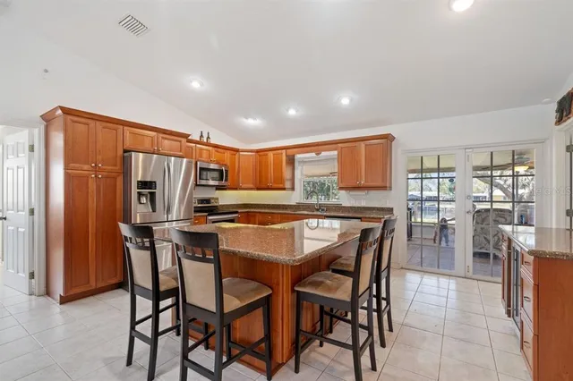 a dining area with stainless steel appliances kitchen island granite countertop a dining table and chairs
