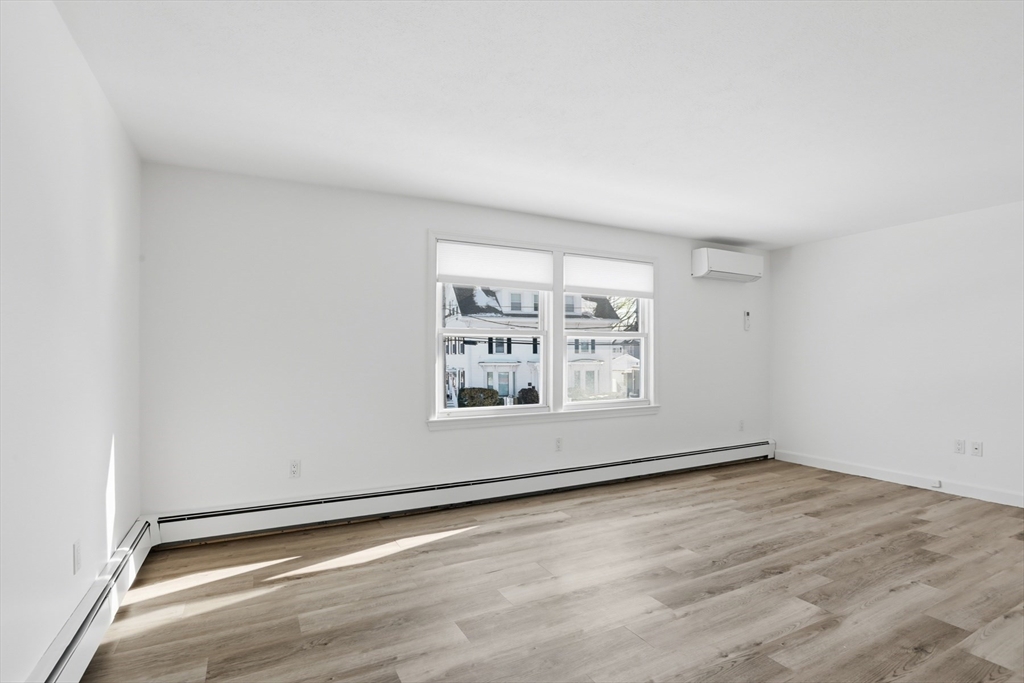 381 South Main Street, Unit 2 Haverhill, MA 01835 - Photo 2 of 18 an empty room with wooden floor and windows