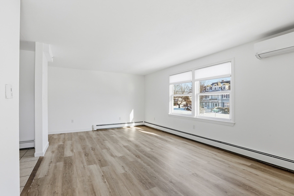 381 South Main Street, Unit 2 Haverhill, MA 01835 - Photo 3 of 18 an empty room with wooden floor and windows