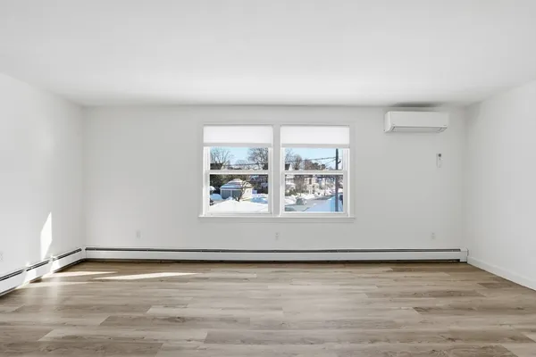a view of a room with wooden floor and window