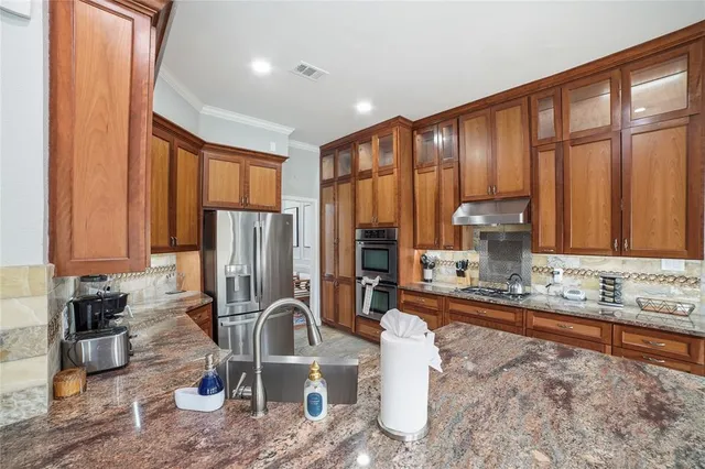 a living room with stainless steel appliances furniture and a flat screen tv