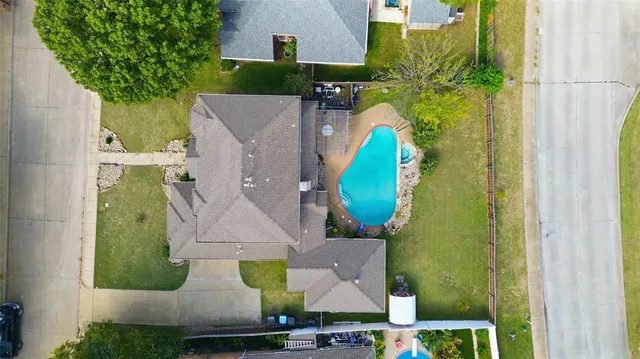 an aerial view of a house with a garden and lake view