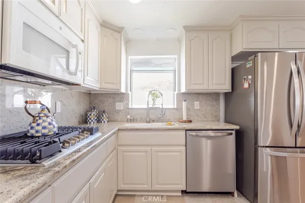 a kitchen with white cabinets and white appliances