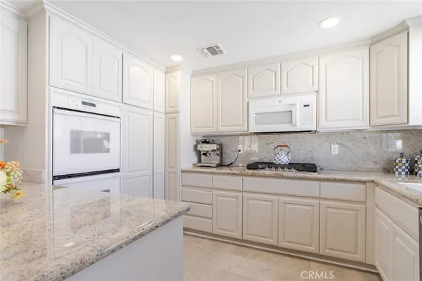 a kitchen with white cabinets and white appliances