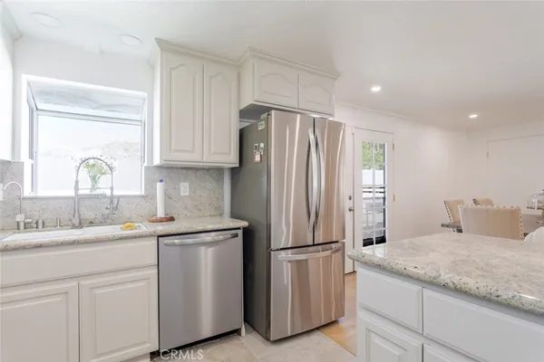 a kitchen with stainless steel appliances granite countertop a refrigerator and a sink