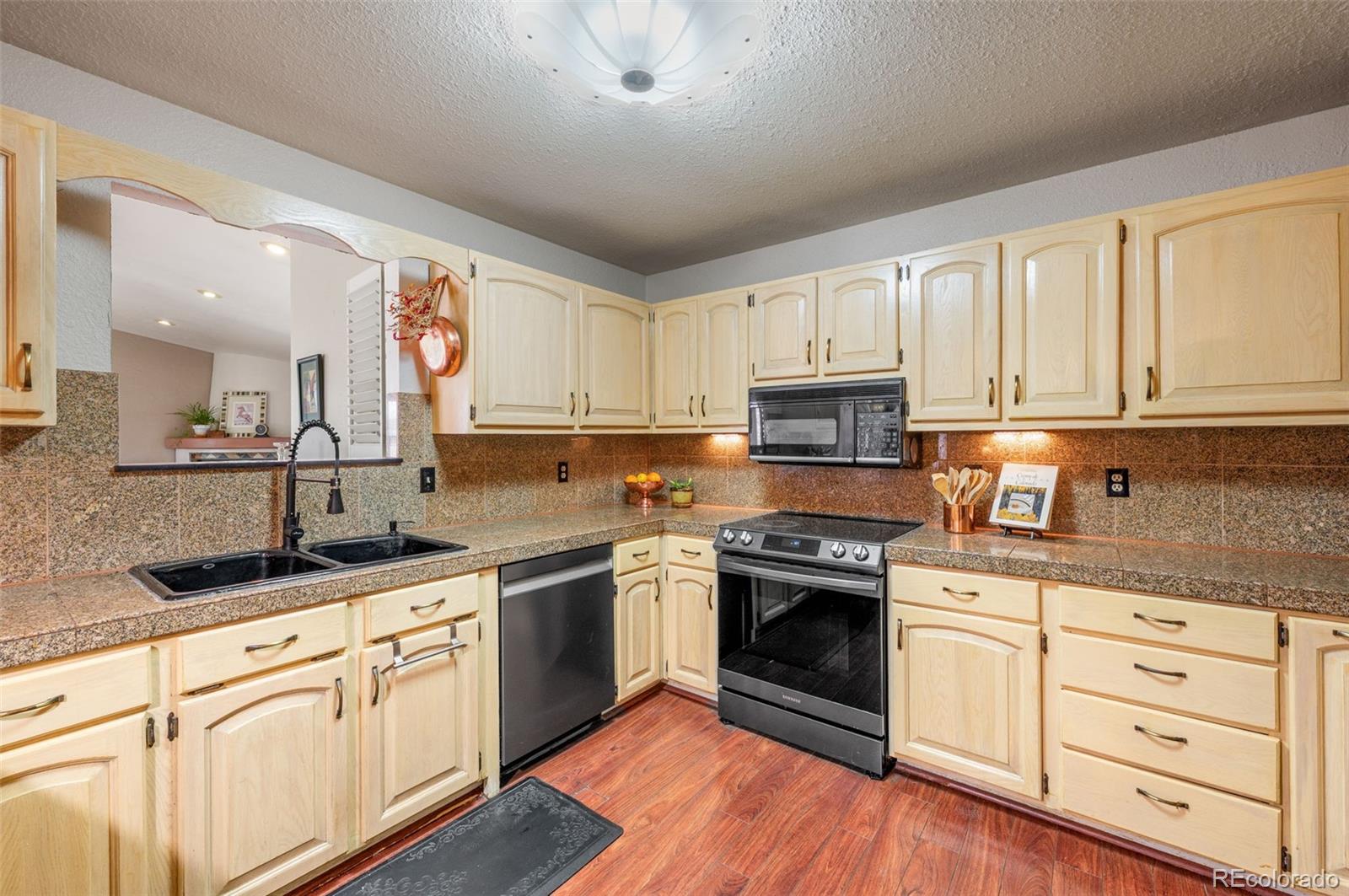 6263 Laodicea Road Longmont, CO 80503 - Photo 25 of 45 a kitchen with granite countertop white cabinets and white appliances