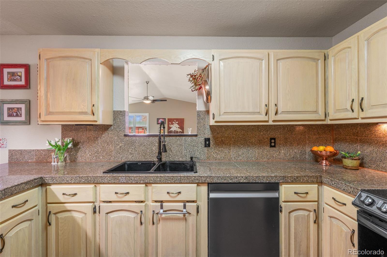 6263 Laodicea Road Longmont, CO 80503 - Photo 27 of 45 a kitchen with granite countertop a sink a stove and cabinets