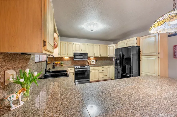 a kitchen with white cabinets and sink