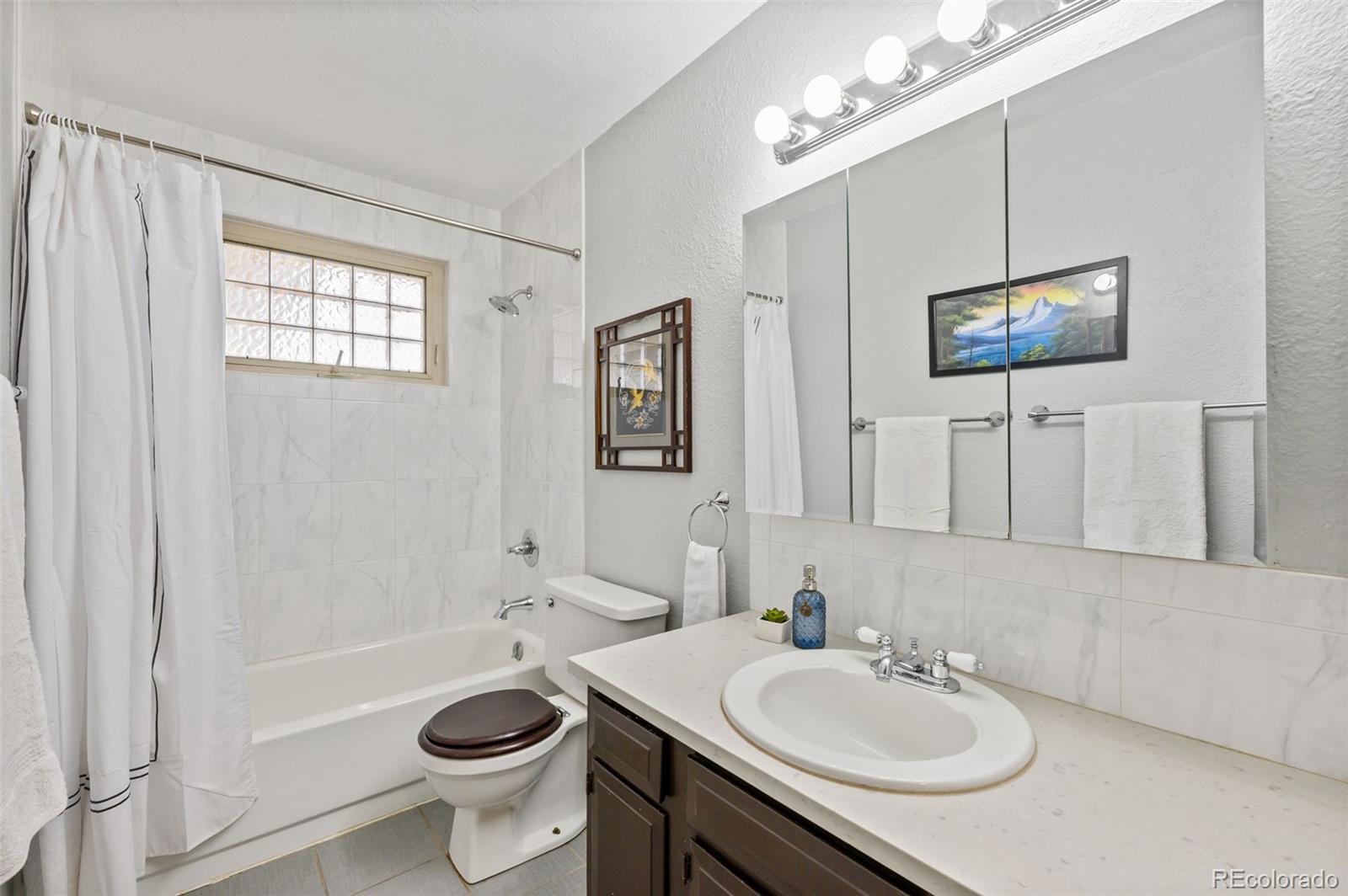6263 Laodicea Road Longmont, CO 80503 - Photo 35 of 45 a bathroom with a sink a toilet a mirror and shower