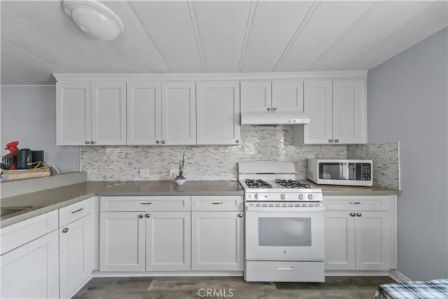 a kitchen with white cabinets and white appliances