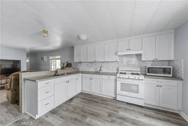 a kitchen with granite countertop white cabinets and white appliances