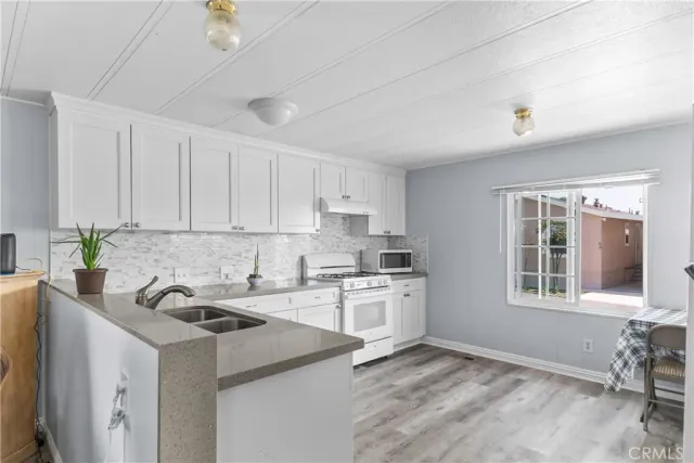a kitchen with stainless steel appliances granite countertop a sink stove and cabinets