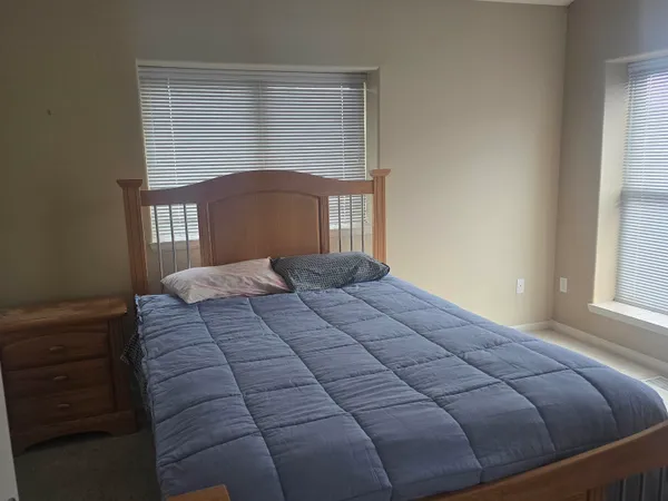 a bedroom with a large bed and a window