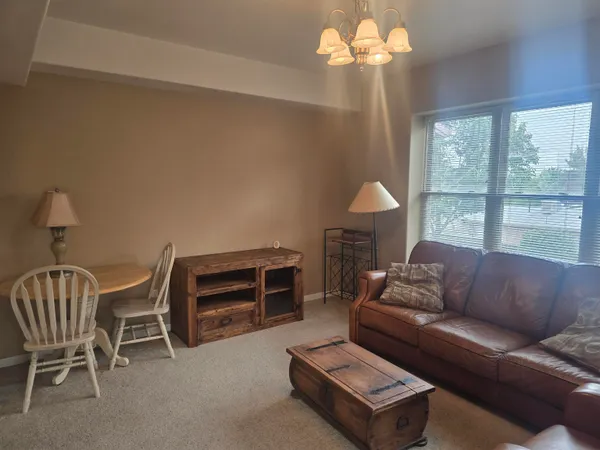 a living room with furniture a chandelier and a window