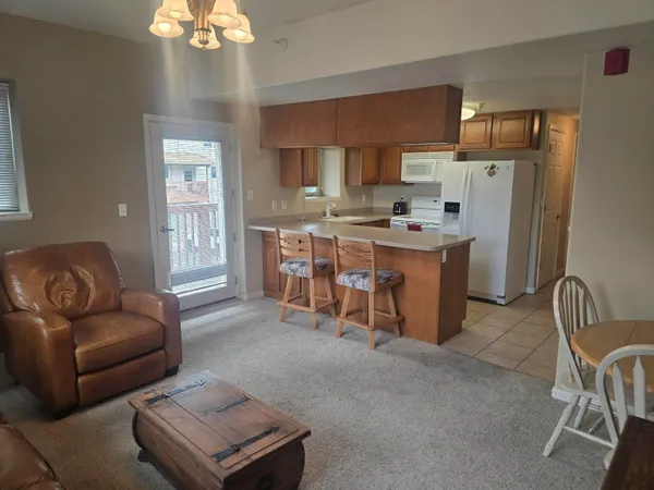 a living room with stainless steel appliances granite countertop furniture a fireplace and a window