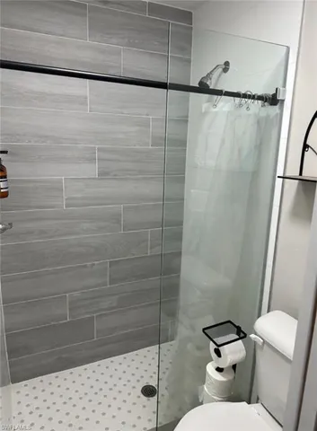 a bathroom with a toilet and a shower