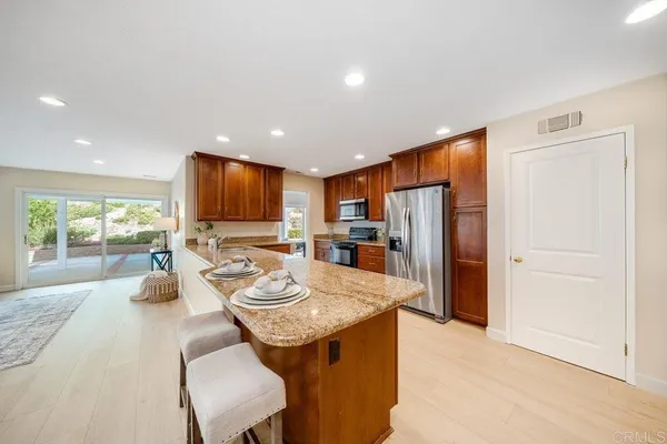 a kitchen with a refrigerator a stove and a sink with wooden floor