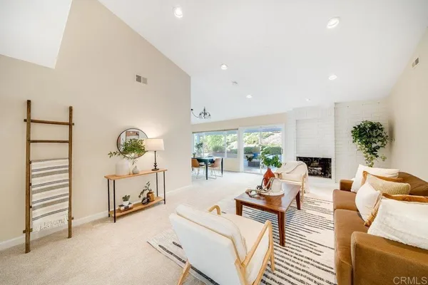 a living room with furniture a fireplace and a potted plant