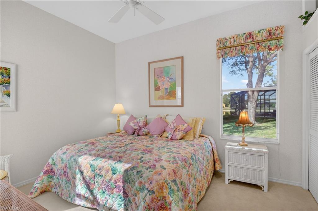 6687 Huntley Lane South Naples, FL 34104 - Photo 21 of 37 a bedroom with a bed and a painting on the wall