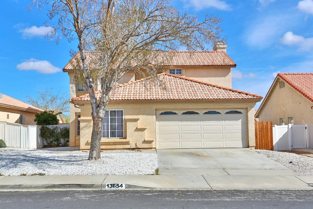 13654 Foxfire Road Victorville, CA 92392 - Photo 1 of 1 a front view of a house with a yard and garage
