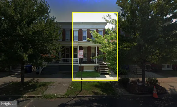 a view of a brick house with a small yard