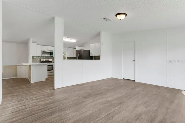 a view of a kitchen with wooden floor and electronic appliances