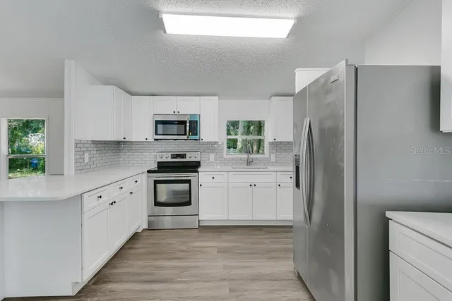 a kitchen with a refrigerator stove and microwave