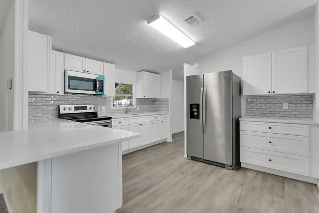 a kitchen with stainless steel appliances a refrigerator stove and microwave