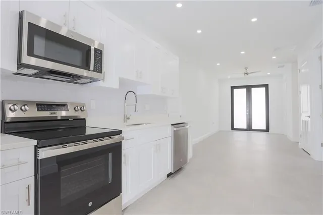 a kitchen with a refrigerator sink and cabinets