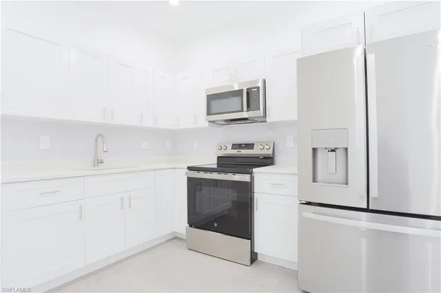 a kitchen with stainless steel appliances a refrigerator sink and cabinets