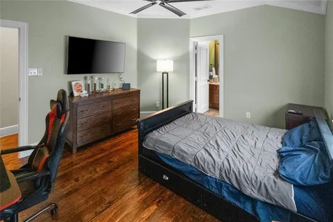 a bedroom with a bed and a flat tv screen on a dresser
