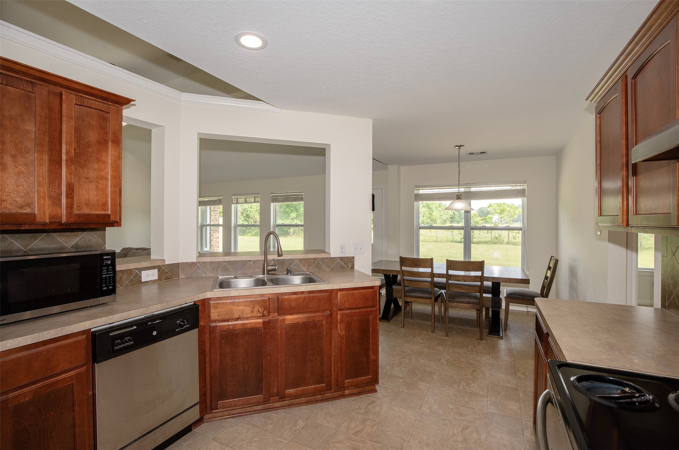 6105 Del Bello Boulevard Manvel, TX 77578 - Photo 20 of 37 a kitchen with stainless steel appliances granite countertop a sink a stove a table and chairs