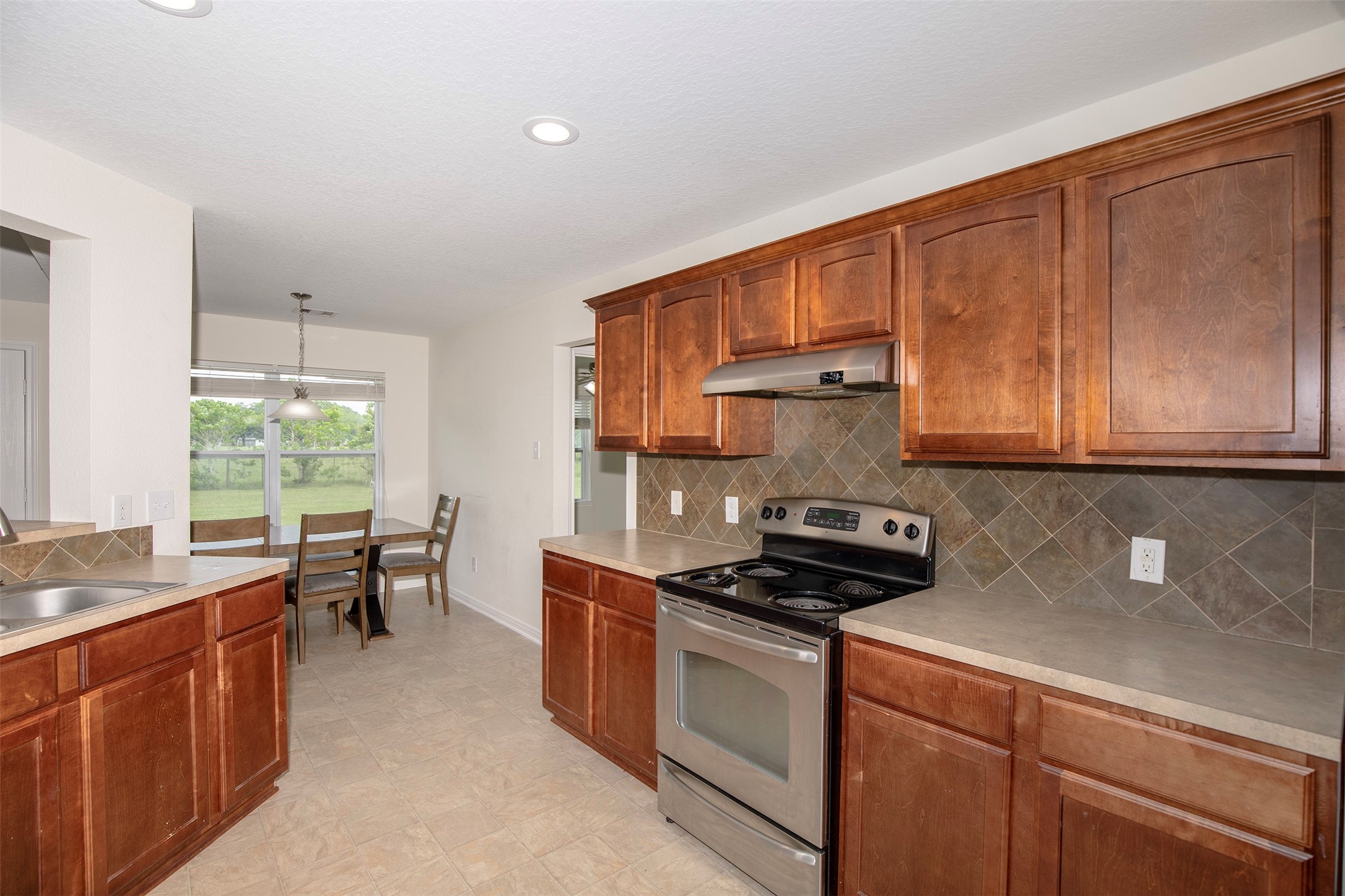6105 Del Bello Boulevard Manvel, TX 77578 - Photo 21 of 37 a kitchen with stainless steel appliances granite countertop a sink stove and cabinets