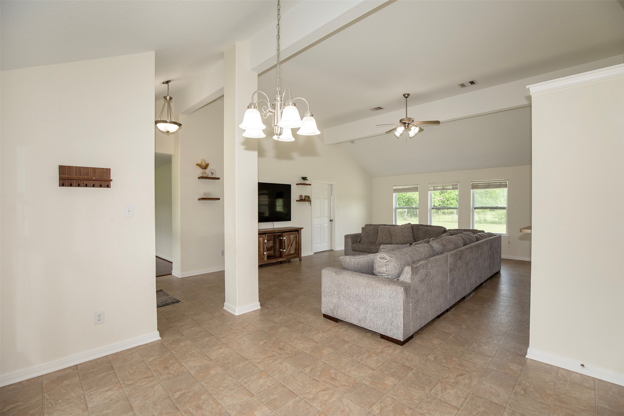 6105 Del Bello Boulevard Manvel, TX 77578 - Photo 10 of 37 a living room with furniture a chandelier and a flat screen tv