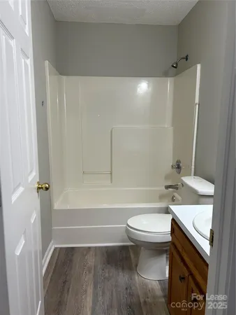 a bathroom with a granite countertop toilet a sink and bathtub
