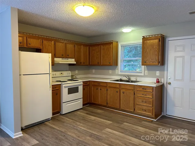 a kitchen with stainless steel appliances granite countertop a refrigerator and a stove top oven