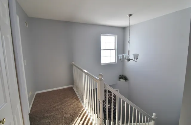 an empty room with closet and a chandelier fan