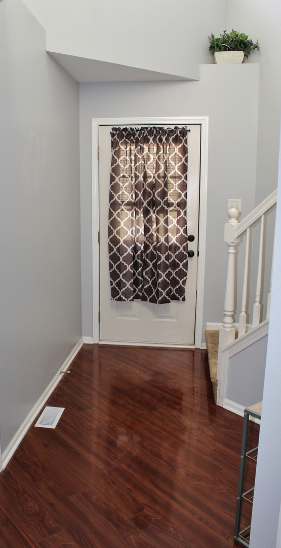 651 Chestnut Ridge Minooka, IL 60447 - Photo 2 of 33 a view of an empty room with wooden floor and a window
