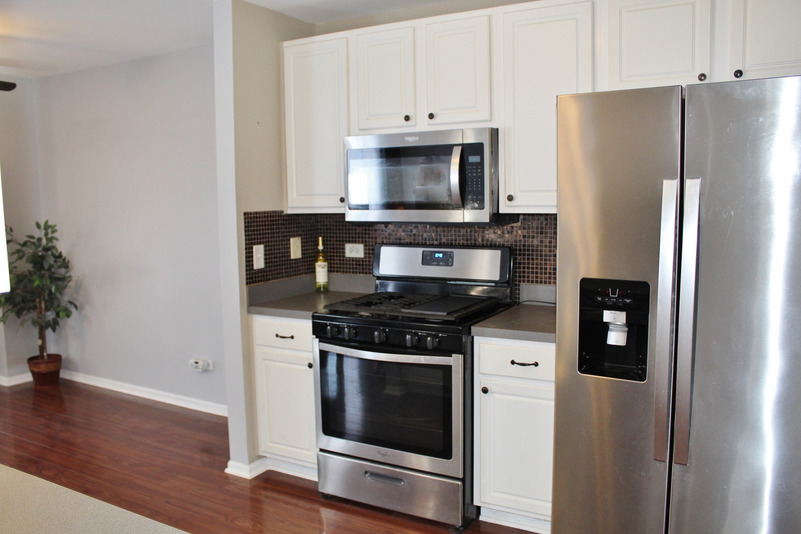 651 Chestnut Ridge Minooka, IL 60447 - Photo 7 of 33 a kitchen with stainless steel appliances a stove a microwave and a refrigerator