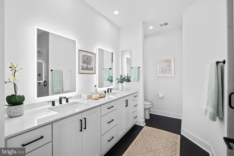a spacious bathroom with double vanity and a mirror