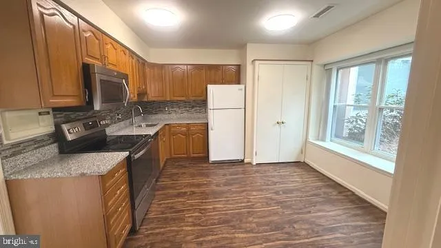 a kitchen with stainless steel appliances granite countertop a sink stove and refrigerator