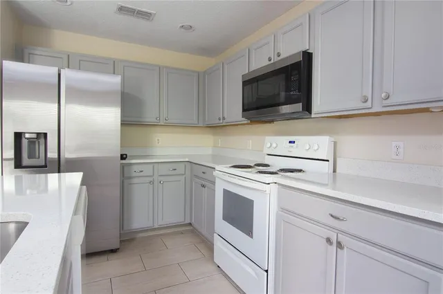 a kitchen with cabinets stainless steel appliances and counter space