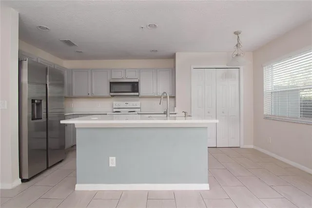 a kitchen with stainless steel appliances granite countertop a sink and a refrigerator