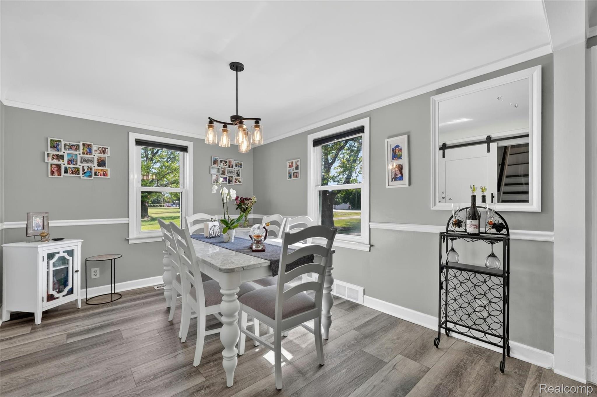2861 John R Road Rochester, MI 48307 - Photo 16 of 54 Dining area featuring wood-finish flooring, two windows, crown molding, and a contemporary chandelier