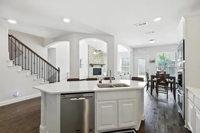 a dining hall with stainless steel appliances kitchen island a stove a table and chairs