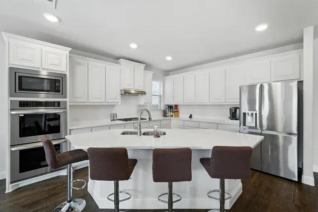 a kitchen with stainless steel appliances granite countertop a refrigerator and microwave