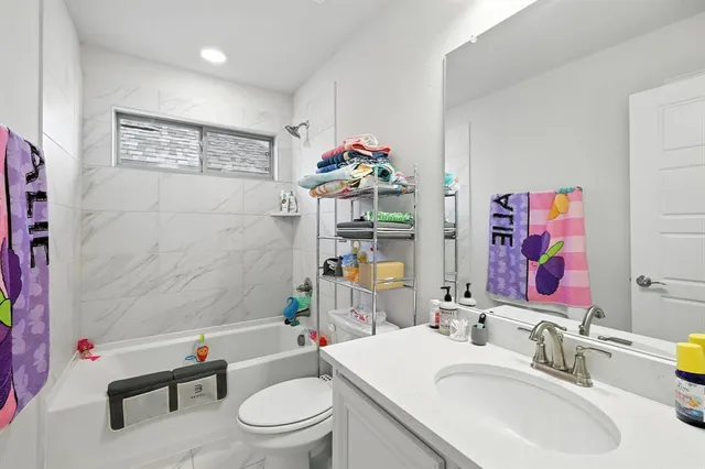 a bathroom with a sink mirror vanity and toilet